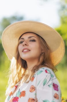 Beautiful young woman in summer hat posing and looking at the camera. Vertically.