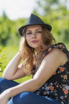 Portrait of beautiful young woman posing in black hat looking at the camera. Vertically.