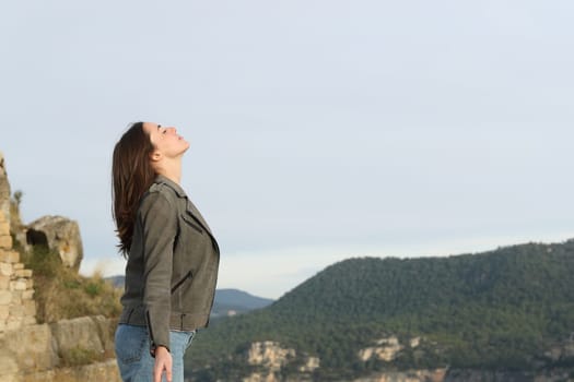 Profile of a casual woman breathing fresh air in the mountain