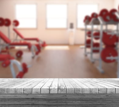 3D render of a white wooden table looking out to a defocussed gym interior