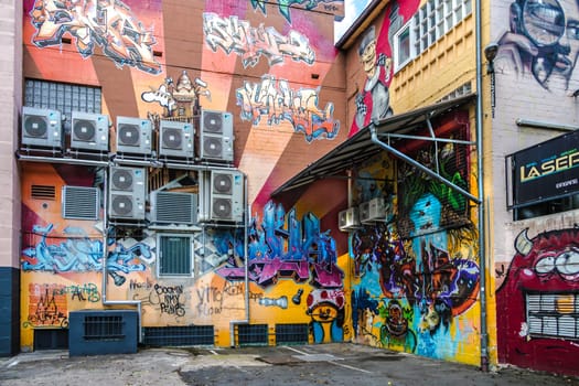 WETZLAR, GERMANY - 23.05.2021: Air conditioner mounted on a house facade with surround colorful graffiti.