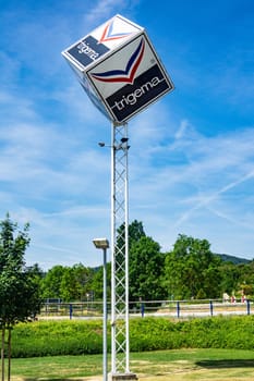 KIRCHHEIM, GERMANY -2019-07-10: TRIGEMA Logo Advertisement. TRIGEMA was established in 1919 and is Germany’s largest manufacturer of sportswear and casual fashion.