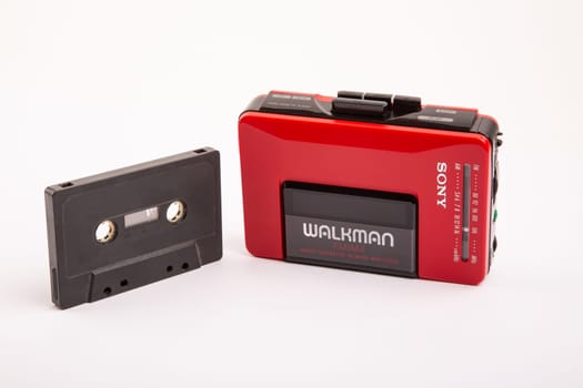 HUETTENBERG, GERMANY - 2021-04-07: Beautiful red vintage SONY WALKMAN WM-24 with black audio cassette over bright background.