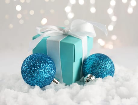 Christmas gift and baubles nestled in snow
