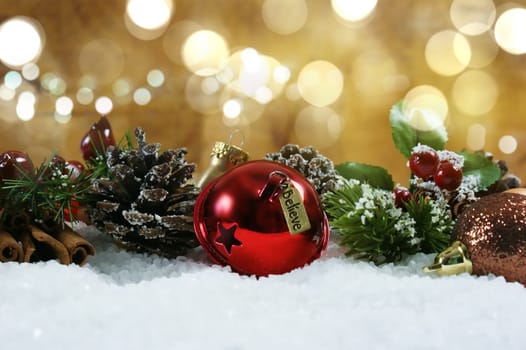 Christmas bell with tag saying believe nestled in snow