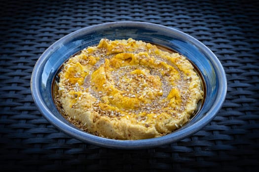 Hummus (or houmous) over dark blue