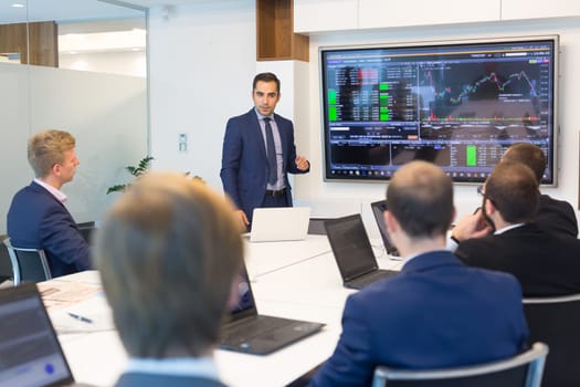 Business man making a presentation at office. Business executive delivering a presentation to his colleagues during meeting or in-house business training, explaining business plans to his employees.