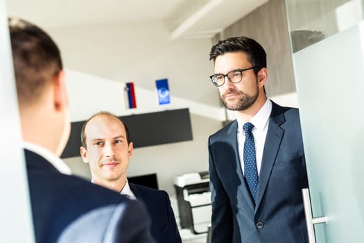 Group of confident business people greeting with a handshake at business meeting in modern office. Closing the deal agreement by shaking hands. Business and entrepreneurship success concept.