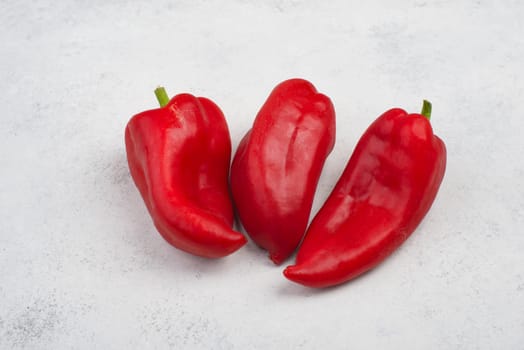 Fresh red paprika isolated on a white textured background, empty copy space for text