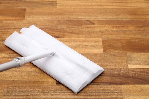Part of flat wet paper mop and disposable working head on wooed floor