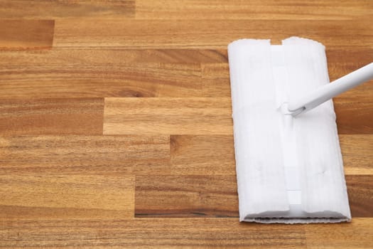 Part of flat wet paper mop and disposable working head on wooed floor