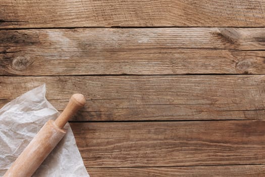 Ingredients for baking and kitchen utensils on old wooden background. Cooking baking dough, preparing flour, rocking pin, parchment paper. Baking concept flat lay photo with copy space