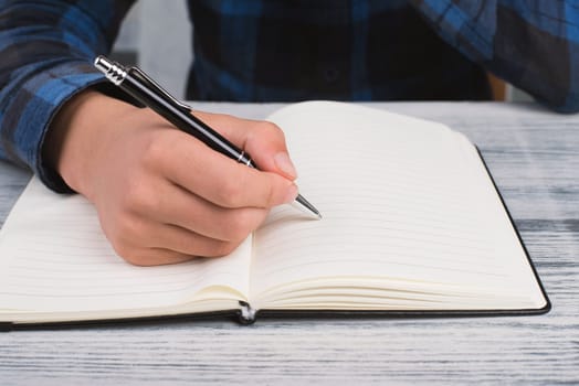 Writing into a book, empty copy space for text, hand with a pen