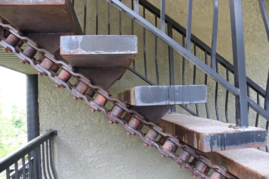 Closeup of large stairs made with large machinery chains.
