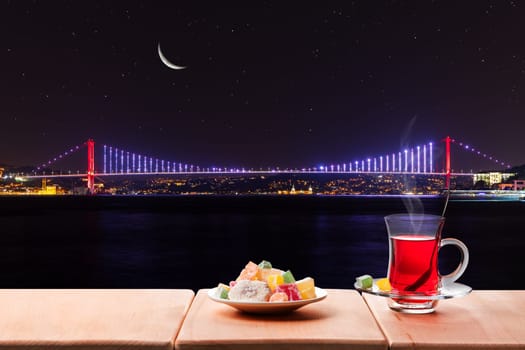 Turkish tea party near the Bosphorus bridge at night, Istanbul, Turkey.