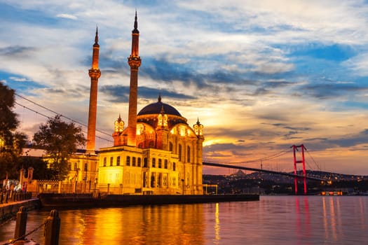 A Grand Imperial Mosque of Istanbul and the Bosphorus bridge in the night lights.