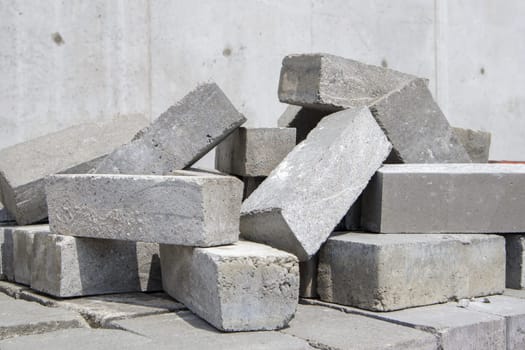 A pile of cement type bricks. Solid brick is used for construction. Lots of loose concrete bricks at the construction site