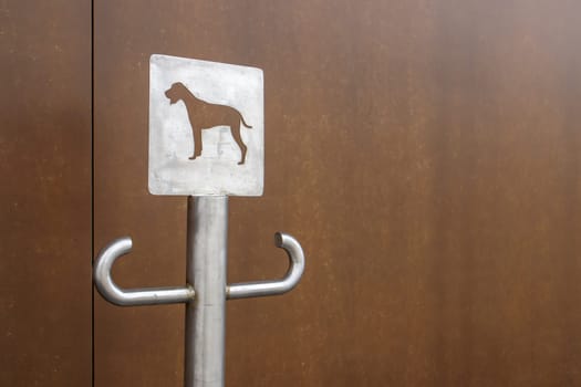 Close-up of an outdoor dog parking sign. A place for a leash for dogs waiting for their owners on the street. Attach a leash, in public places or at the entrance to the store. Copy space