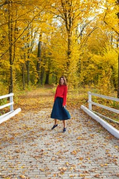 Beautiful park. Golden autumn. The girl is spinning on the track near a beautiful park