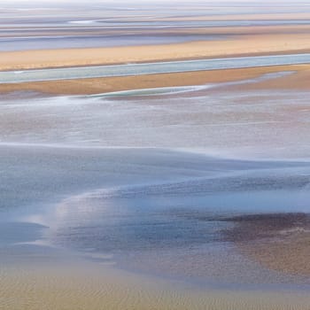 flowing sea water on sand at low tide in the bay of Mont Saint-Michel, abstract composition