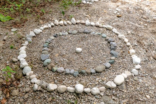Circles of white and gray pebbles on the bank of a stream