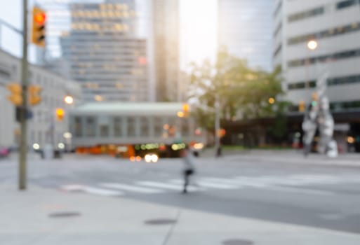 Blurred a man crossing the street in the city with traffics light bokeh and buildings for background