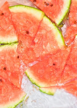 Close up view of the red melon slices in lemonade background. Texture of cooling sweet summer's drink with macro bubbles on the glass wall. Flat design.