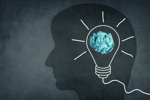 Silhouette of a face with a lightbulb, textured background, empty copy space for text