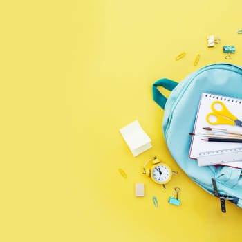 Back to school conceptual flat lay with different office supply items and copy space area for text. Concept for primary and secondary school pupil. Pupil blue back pack bag with variety office supply