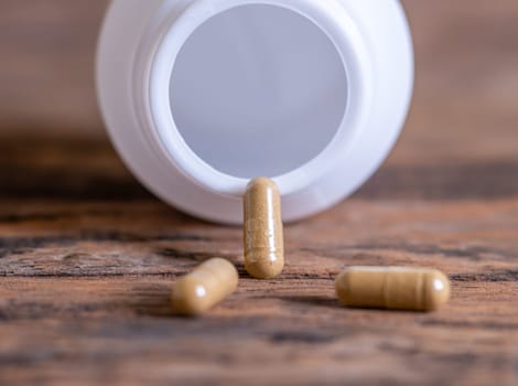 Pill spilling out of a bottle blurred background, Medicine capsule for health, Vitamin spilling out from bottle, Macro