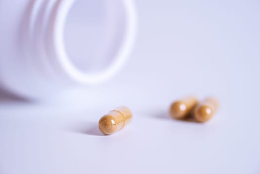 Pill spilling out of a bottle blurred background, Medicine capsule for health, Vitamin spilling out from bottle, Macro