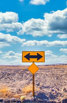 Directional sign in the desert with scenic blue sky and wide horizon. Concept for trip, freedom, holiday and transportation.