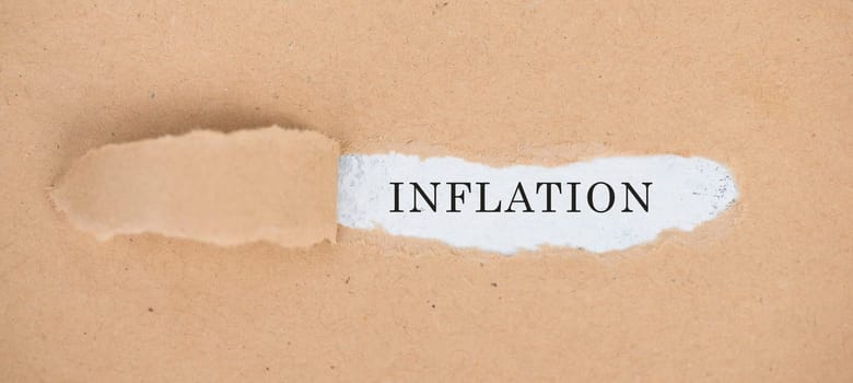 The word inflation is standing on a white background, ripped textured paper