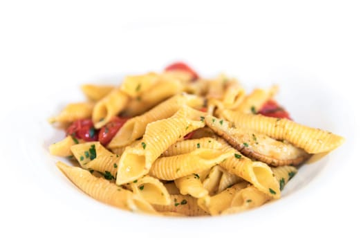Rustic penne Italian pasta with mushrooms, cherry tomatoes, basil and olive oil. Close-up. Shallow DOF. Copy space.