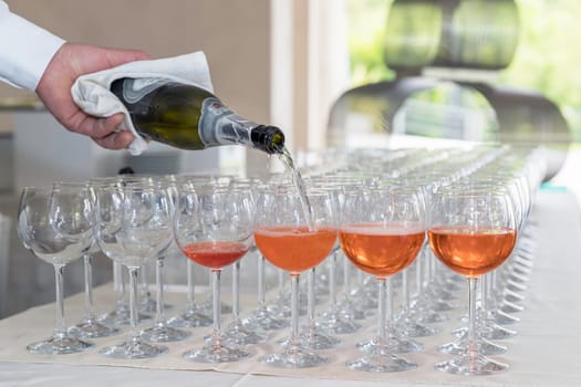 Bartender making spritz cocktail. Barman serving orange liqueur cocktail in many wineglass.