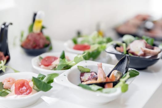 Light seafood snacks on a buffet table. Assorted mini quick, delicacies and snacks, restaurant seafood at event. Wedding party. Gala reception. Decorated delicious table for a party goodies.
