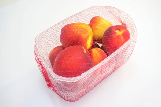 Nectarines on their plastic package covered. Closeup