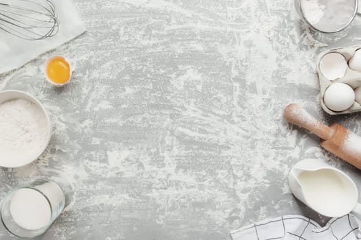 Baking ingredients, kitchen utensils, on grey concrete background flat lay, copy space. Cooking Christmas or New Year cookies, bread, cakes. Prepare dough from eggs, flour, milk, oil, butter, sugar