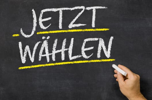 Text on a blackboard - Vote now in german - Jetzt wählen