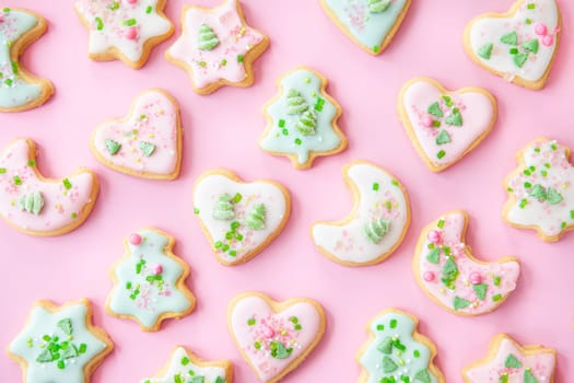 Colorful Christmas cookies with sugar sprinkles on a pink background