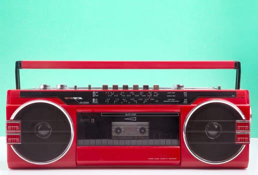 Red vintage Tape player isolated on green and white background