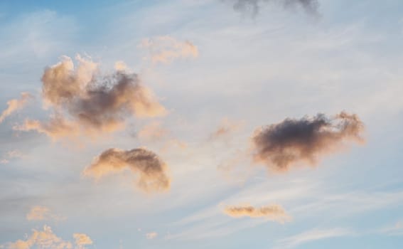Evening sky with some yellow orange , white, grey and dark clouds.