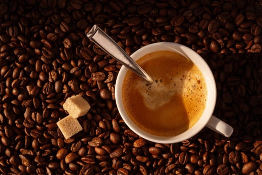 White coffee cup and coffee beans around, top view