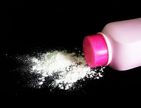 Baby talcum powder pink container on black background