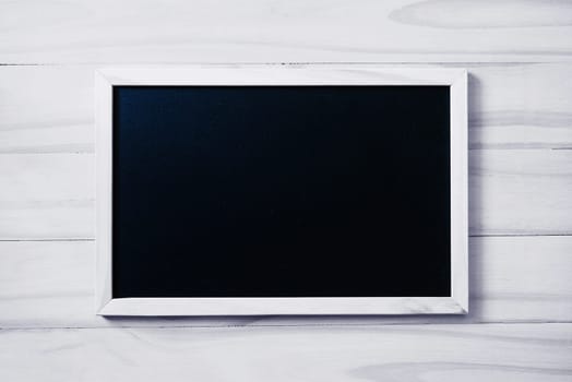 Blank blackboard on white wood background with copy space for your text.