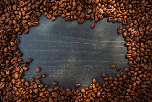 Coffee beans over slate. Top view. Free space for text