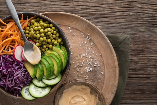 Healthy vegetable meal with avocado and cooked vegetables on wooden table close up