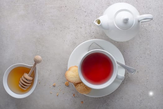 Tea cup and tea pot with fruit, herbal with honey on grey table background