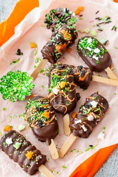 Halloween cake pops, chocolate covered with colorful sugar sprinkles
