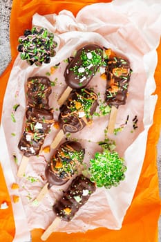Halloween cake pops, chocolate covered with colorful sugar sprinkles
